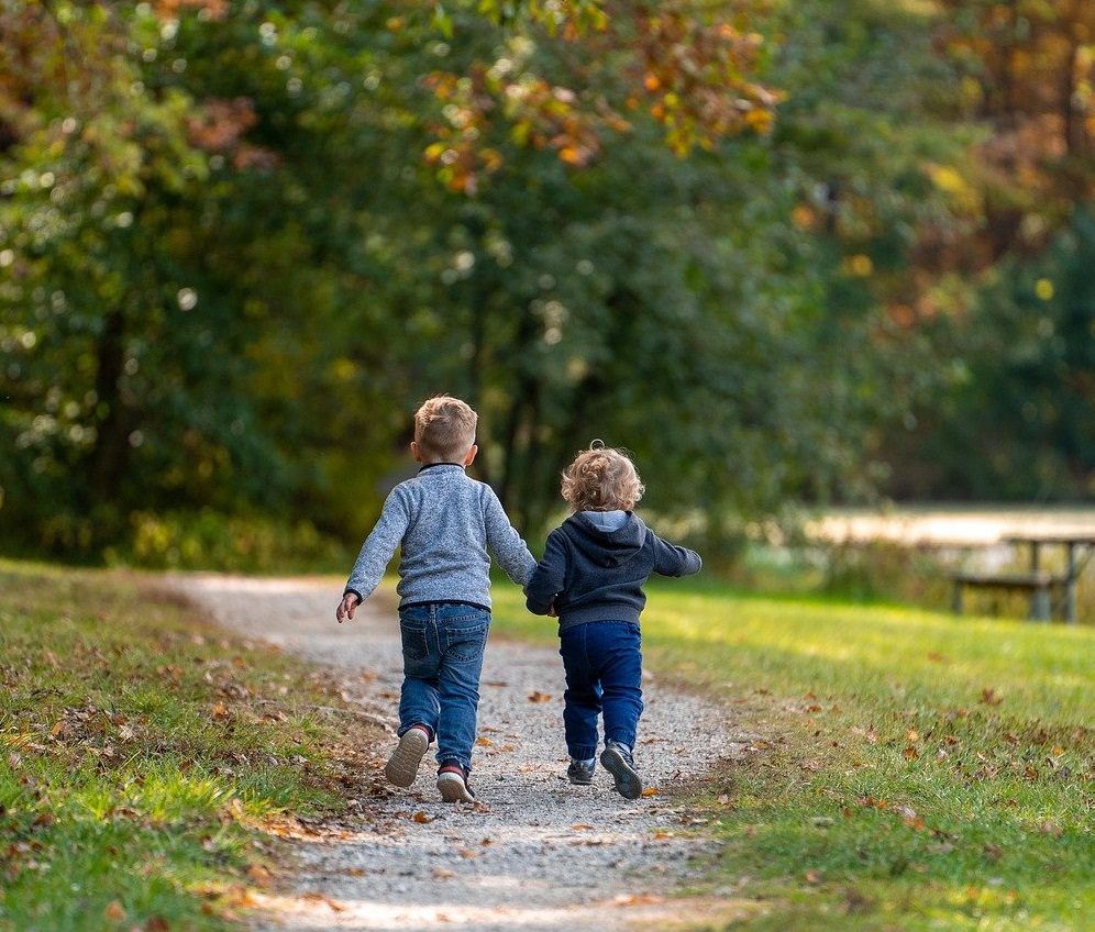 Two boys walking together on a path.