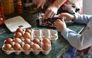 A child helps their parent at home in making a cake.