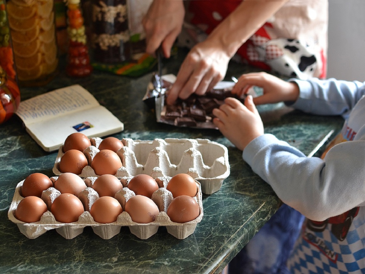 A child helps their parent at home in making a cake.