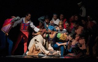 Theatre with actors on stage in middle of a performance.